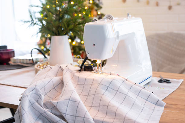 istock Sewing process on a sewing machine, a needle with a thread and a holder close-up stitch the white checkered fabric. Preparation for Christmas and new year, textiles for cozy in festive decor interior 1795255402