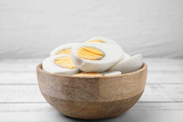 istock Bowl of fresh hard boiled eggs on white wooden table 1795267942
