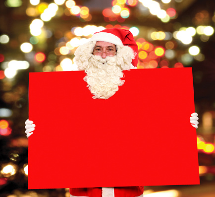 Santa Claus with empty billboard on multicolored background