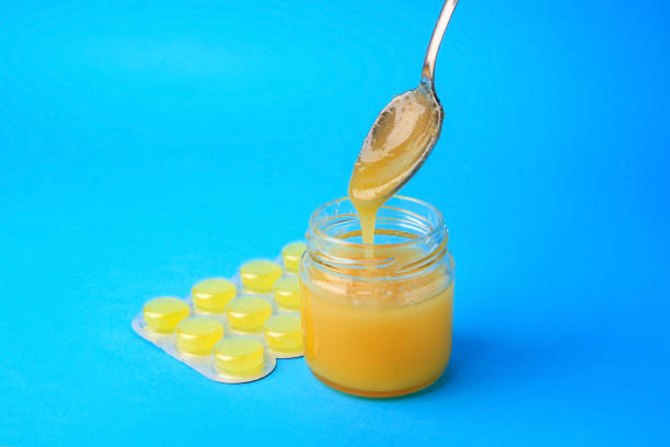 istock Blister with cough drops and honey on light blue background 1795275571