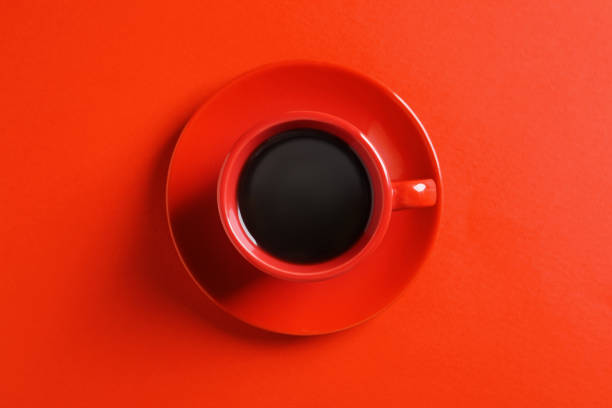 istock Cup with aromatic coffee on red background, top view 1795275979