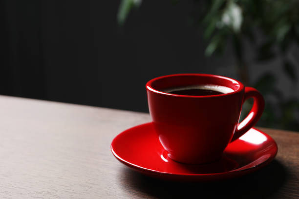 istock Red cup with aromatic coffee on wooden table indoors. Space for text 1795277070