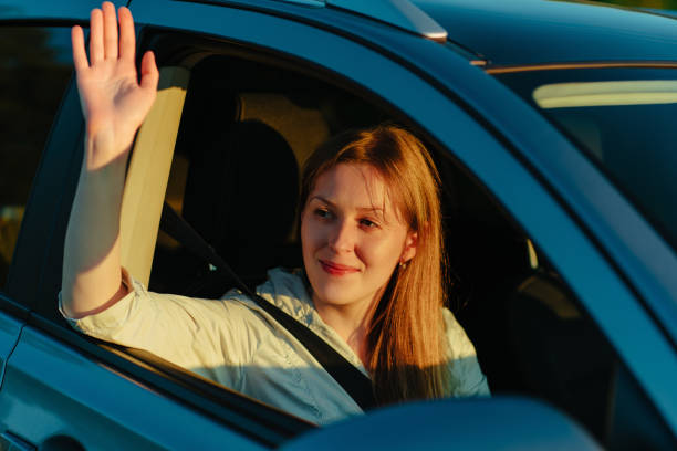 happy young woman waving hand from car window - 12007 imagens e fotografias de stock