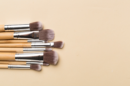 Make up brushes on color background, top view