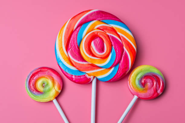 istock Three bright and colourful candy lollipops on a pink background 1795293976