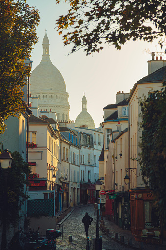 Narrow street on Montmartre with Sacre Coeur Basilica in a background. Paris, France.