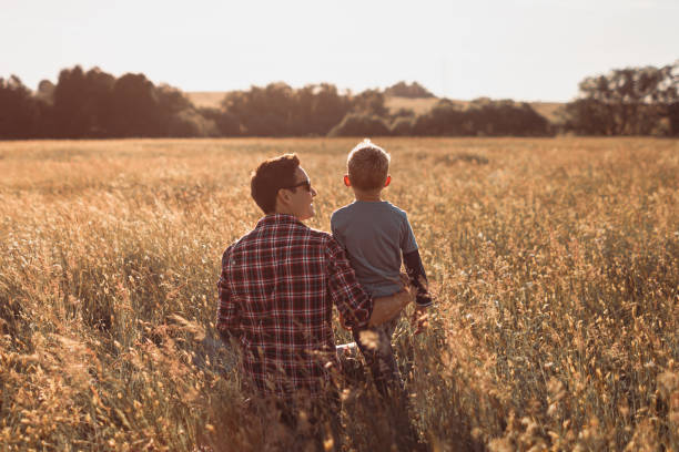 istock Father and son enjoying beautiful sunset if the meadow. 1795320892