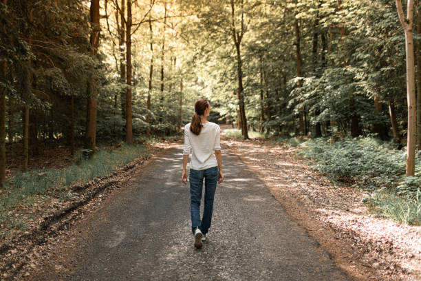 istock Woman walking through the forest. 1795327649