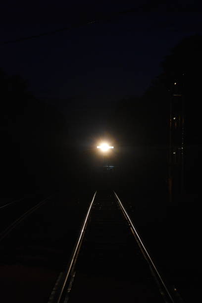 istock Train Lighting the Track at Night 1795327650