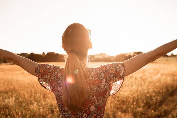 istock Woman feeling and energized in the meadow at sunset. 1795330495