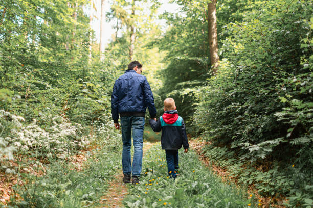 istock Father and son walking together outdoors in the nature setting. 1795335042
