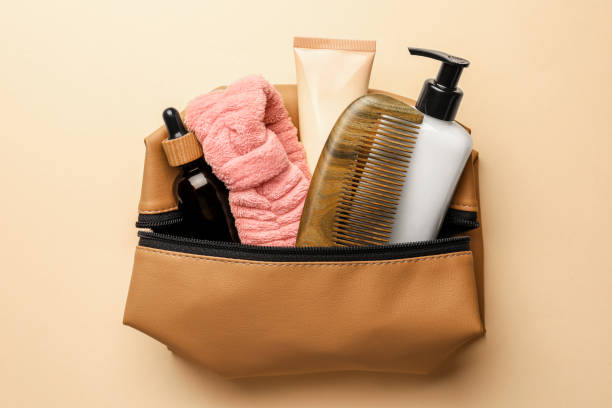 istock Preparation for spa. Compact toiletry bag with different cosmetic products on beige background, top view 1795338526