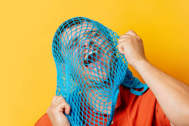 istock Guy with blue net on head on yellow background 1795340289