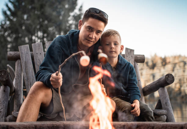 istock Father and son roasting marshmallows over the fire. 1795352140