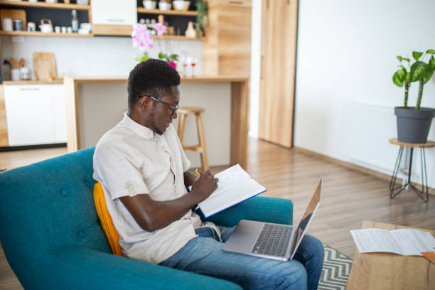 istock Young African man doing his finances at home 1795356206