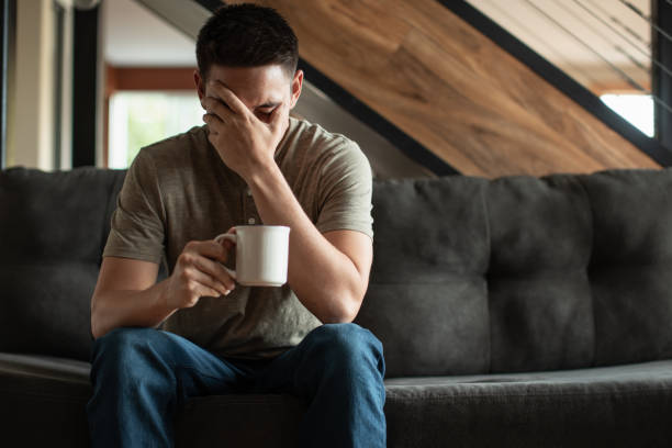 Uomini stressati seduti sul divano di casa. - foto stock