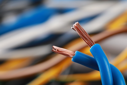 Light blue electrical wire on blurred background, closeup. Space for text