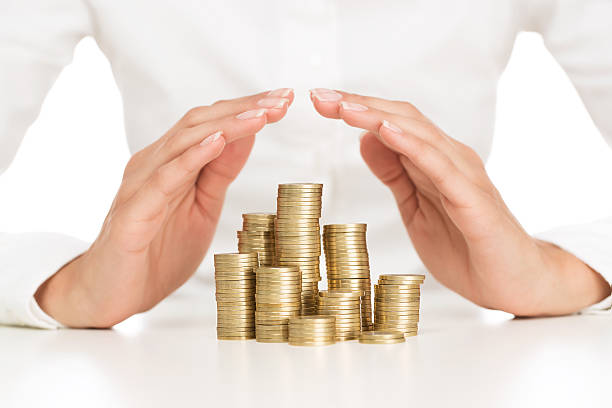 Savings protection Close up of female hands covering stack of golden coins recession protection stock pictures, royalty-free photos & images