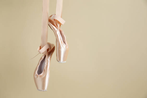 istock Ballet shoes. Elegant pointes hanging on beige background. Space for text 1795376460