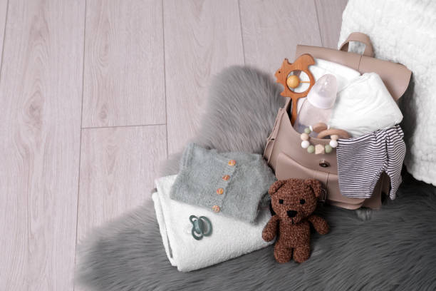 istock Mother's bag with baby's stuff on floor indoors. Space for text 1795376482