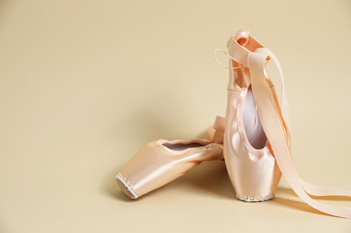 Ballet shoes. Elegant pointes on beige background. Space for text