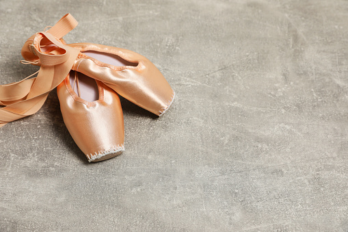 Ballet shoes. Elegant pointes on grey textured background, space for text