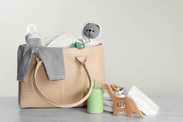 istock Mother's bag with baby's stuff on light grey background 1795377010