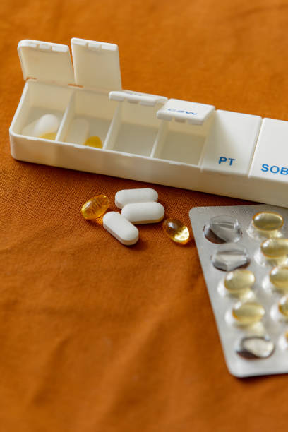 With pills and fish oil next to sorter box on a table