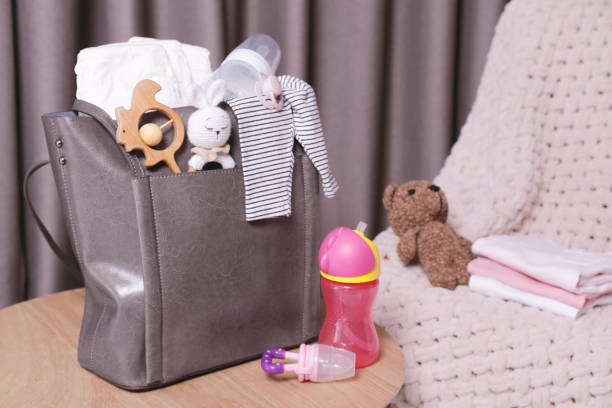 istock Mother's bag with baby's stuff on wooden table indoors 1795378648