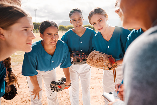 Baseball, team and coach in conversation, talking and speaking about game strategy for a game. Teamwork, collaboration and coaching with women or teens listen to group leader during sport discussion