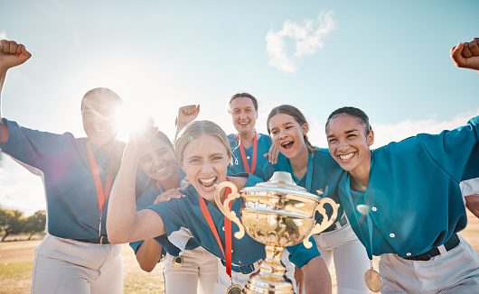 From a low angle perspective, the triumph of teammates raising a gleaming trophy high in the air.