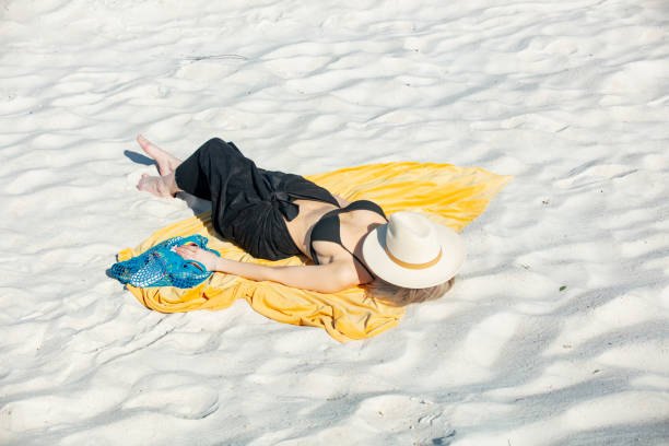 istock Woman lying on beach in bikini and realx 1795382908