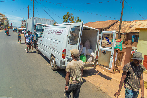 Abeche, Chad - February 14, 2020: Passenger gets into a heavily overloaded old truck. The truck is loaded completely chaotic.