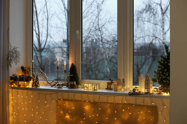 istock Many beautiful Christmas decorations, candlesticks and festive lights on window sill indoors 1795390721
