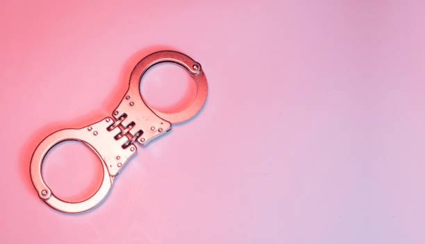 istock Handcuff isolated on pink banner - rape and harassment concept 1795391276