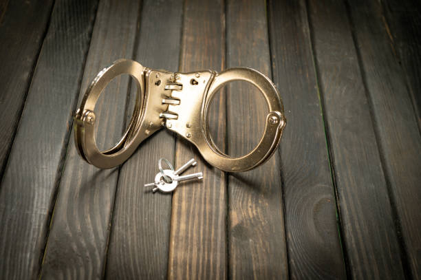 istock Handcuff isolated view on black table top - justice system concept 1795391800
