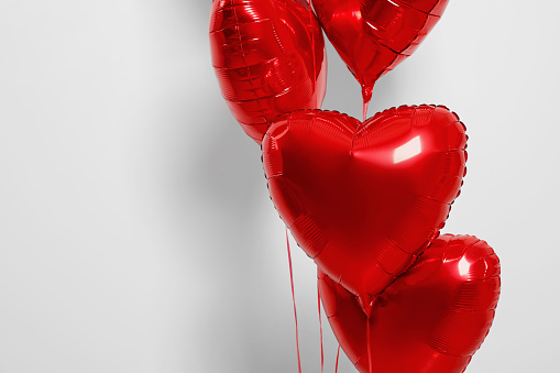 Many red heart shaped balloons on white background, closeup. Space for text
