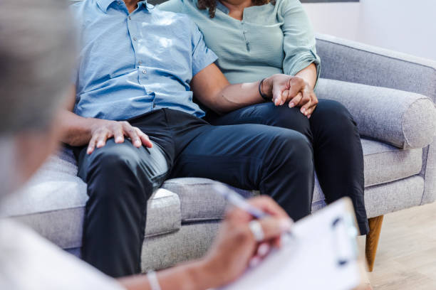 istock Diverse unrecognizable couple holds hands while they meet with their therapist 1795394636