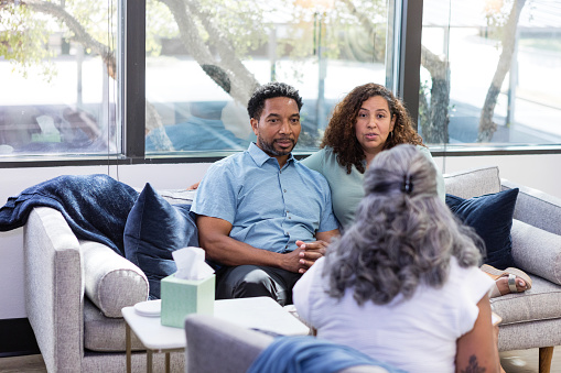 Before getting married, the multiracial couple talks with their marriage counselor in the clinic.