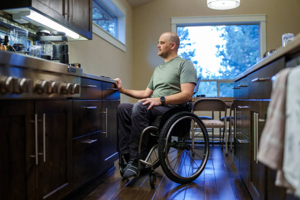 istock Man using wheelchair in the kitchen of his home 1795402695