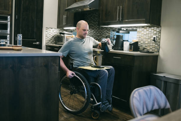 istock Man with physical disability using wheelchair makes coffee at home 1795402699