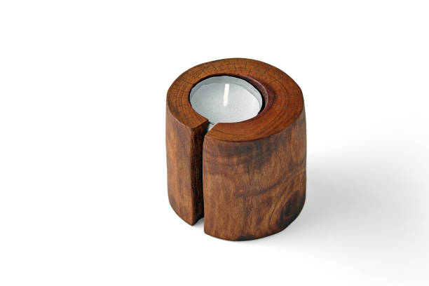 istock Two candles in wooden candlesticks from a tree trunk with a crack isolated on a white background 1795403751
