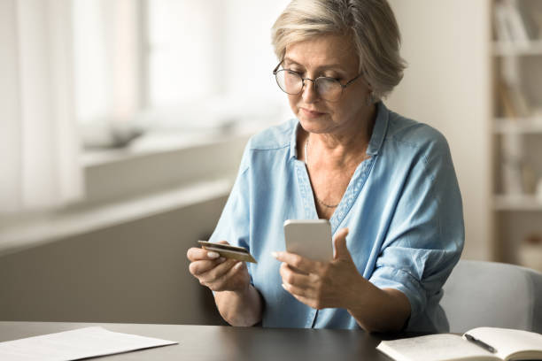 istock Serious senior bank client woman paying on Internet 1795406095