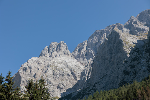 Close up view on a majestic rocky mountain side, illuminated by the sunlight, under a clear sky, in western Friuli Venezia Giulia, in the morning, in summer