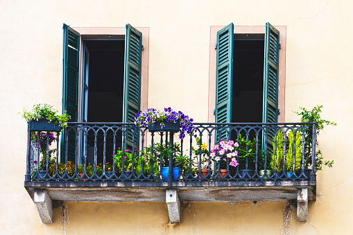 Facade detail : windows with flowers in Italy, in Cannobio, a charming town on Lake Maggiore in Piedmont.
