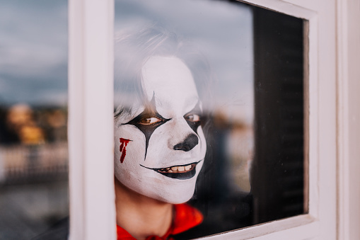 Boy in costume looking in the window on Halloween