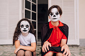 Children sitting on the front porch on Halloween