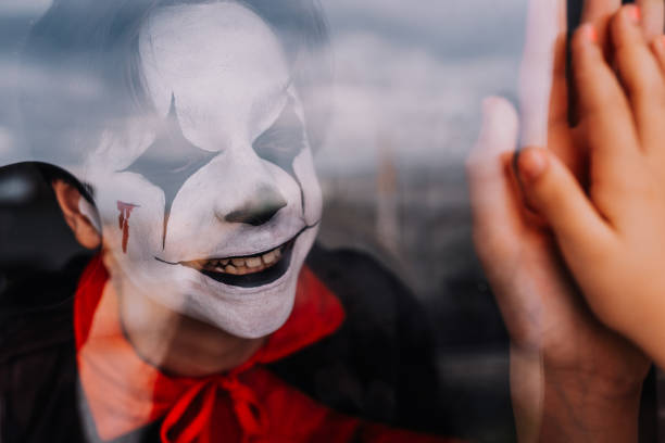 Boy in costume looking in the window on Halloween