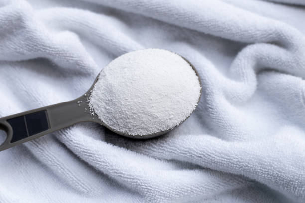 istock Detergent powder in measuring spoon with towel. Laundry concept. 1795445555