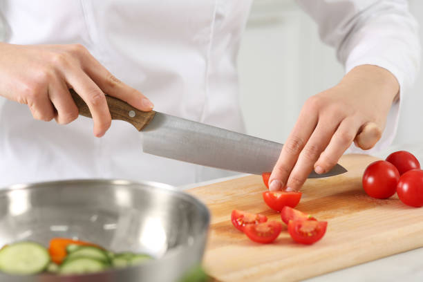 istock Professional chef cutting fresh tomatoes at white marble table in kitchen, closeup 1795475630